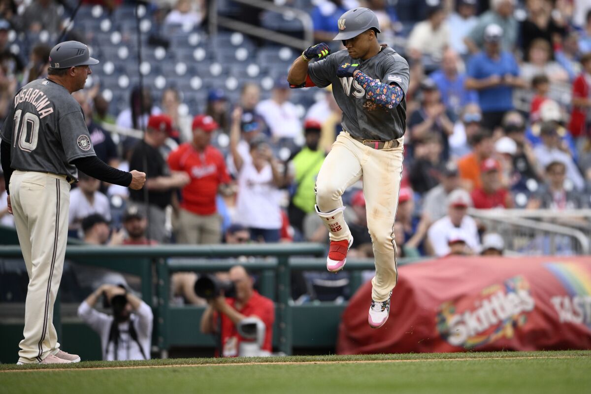 Washington Nationals' Juan Soto, right, celebrates his two-run home run with third base coach Gary Disarcina (10) as he rounds the bases during the fifth inning of a baseball game against the Milwaukee Brewers, Saturday, June 11, 2022, in Washington. (AP Photo/Nick Wass)