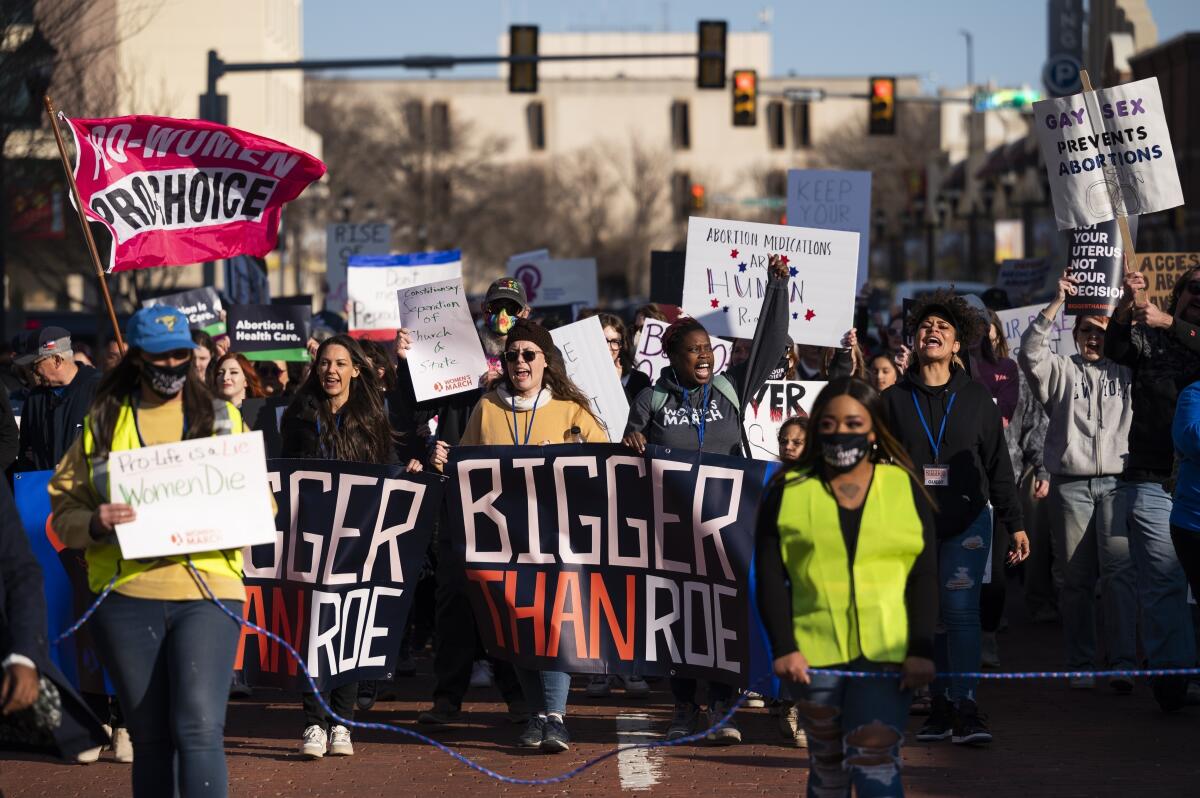 People march with signs last year against a lawsuit to ban an abortion drug.