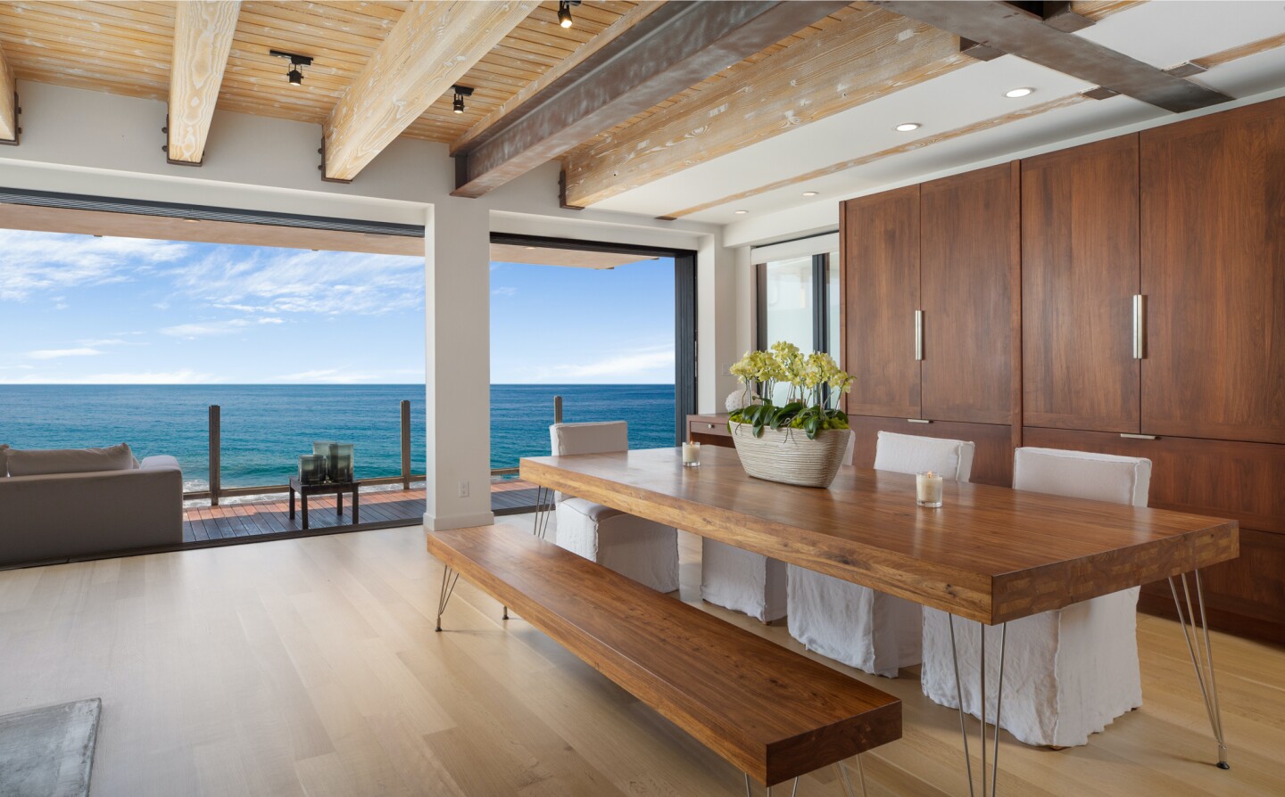 The architectural beach house expands to two levels of wood decks overlooking the ocean.