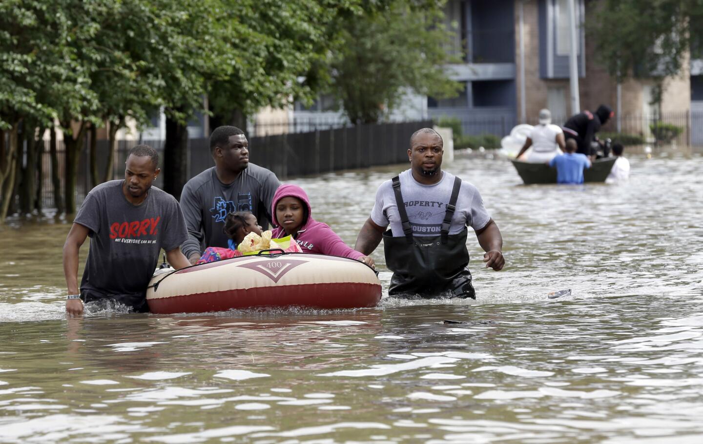 Residents are evacuated from their apartment complex surrounded by floodwaters in Houston. Storms have dumped more than a foot of rain in the Houston area, flooding dozens of neighborhoods and forcing the closure of city offices and the suspension of public transit.