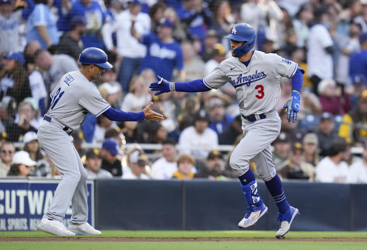 The Dodgers' Chris Taylor (3) is greeted by third base coach Dino Ebel after hitting a two-run home run May 6, 2023.