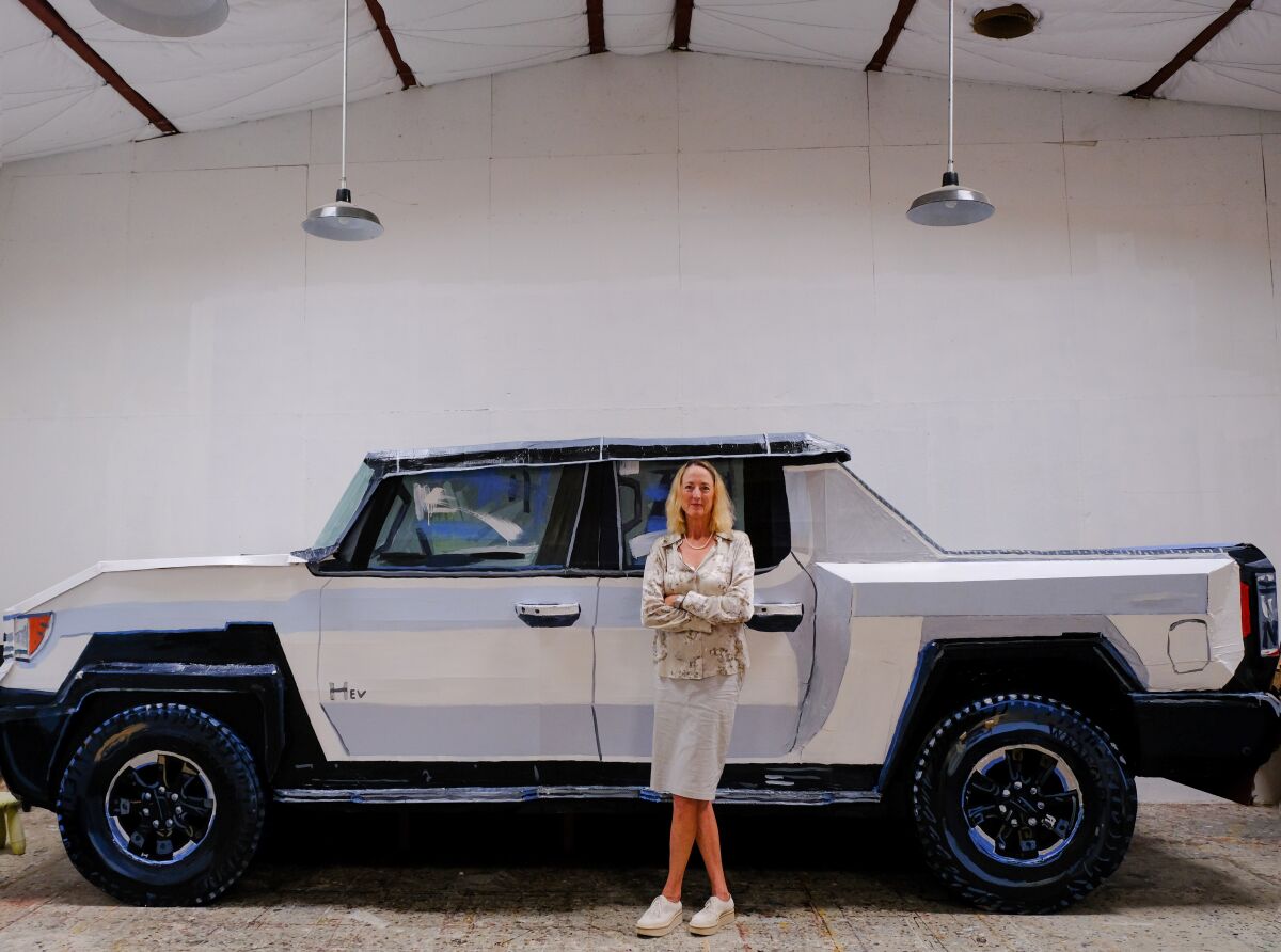 Artist Jean Lowe with the papier-mache Hummer she built for her Quint Gallery show, "Swank."