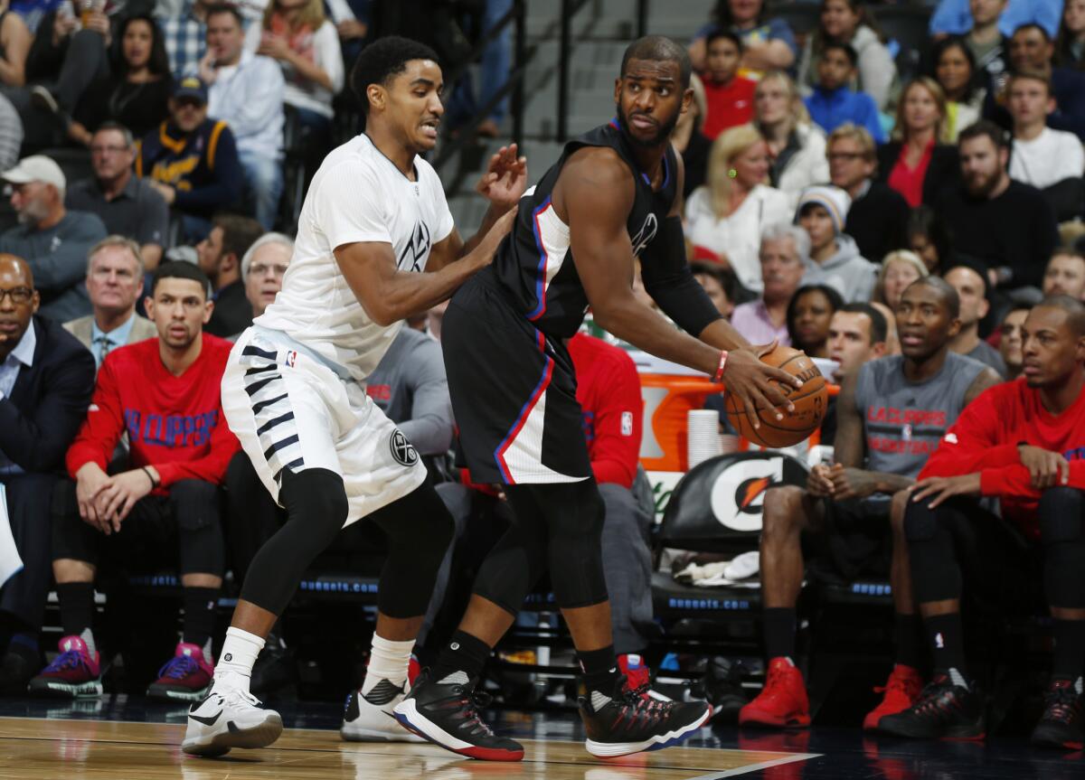 Clippers guard Chris Paul pulls in a loose ball as Nuggets guard Gary Harris defends during the second half of a game in Denver on Nov. 24.