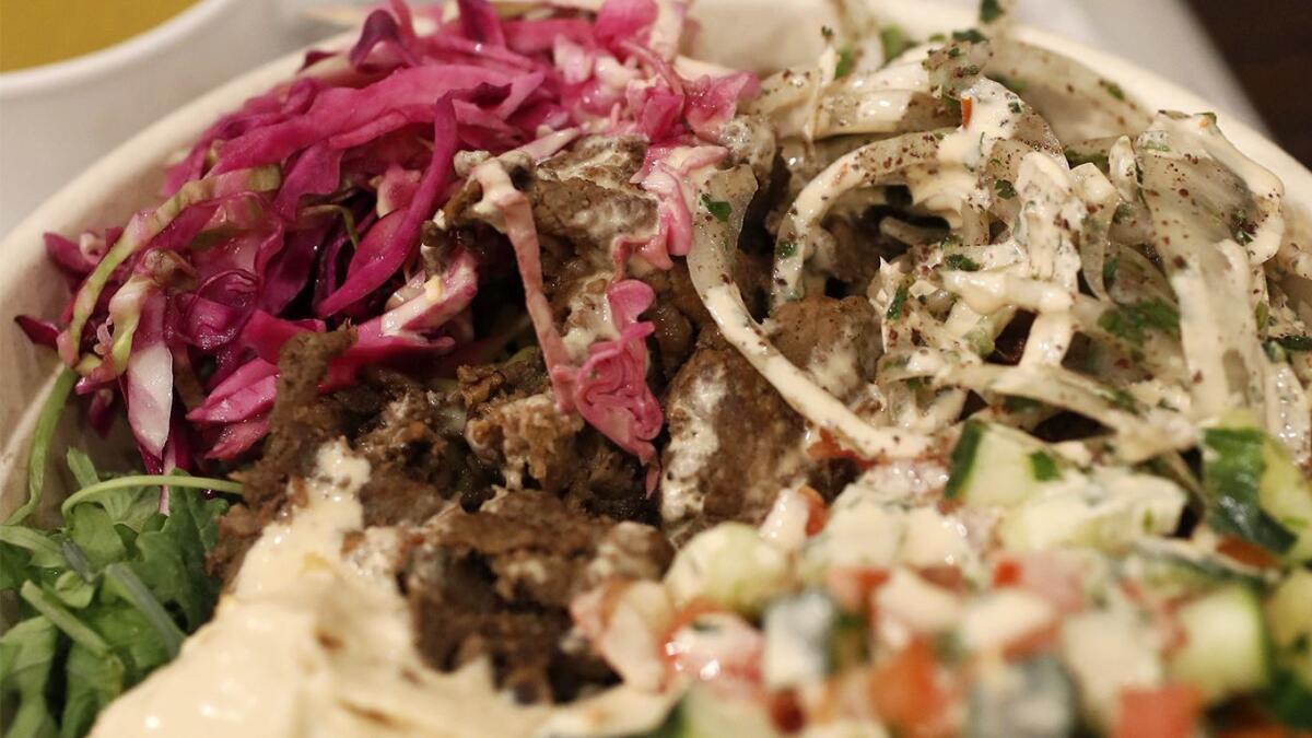 Steak shawarma rice bowl with mixed greens at SAJJ Mediterranean restaurant in Irvine.