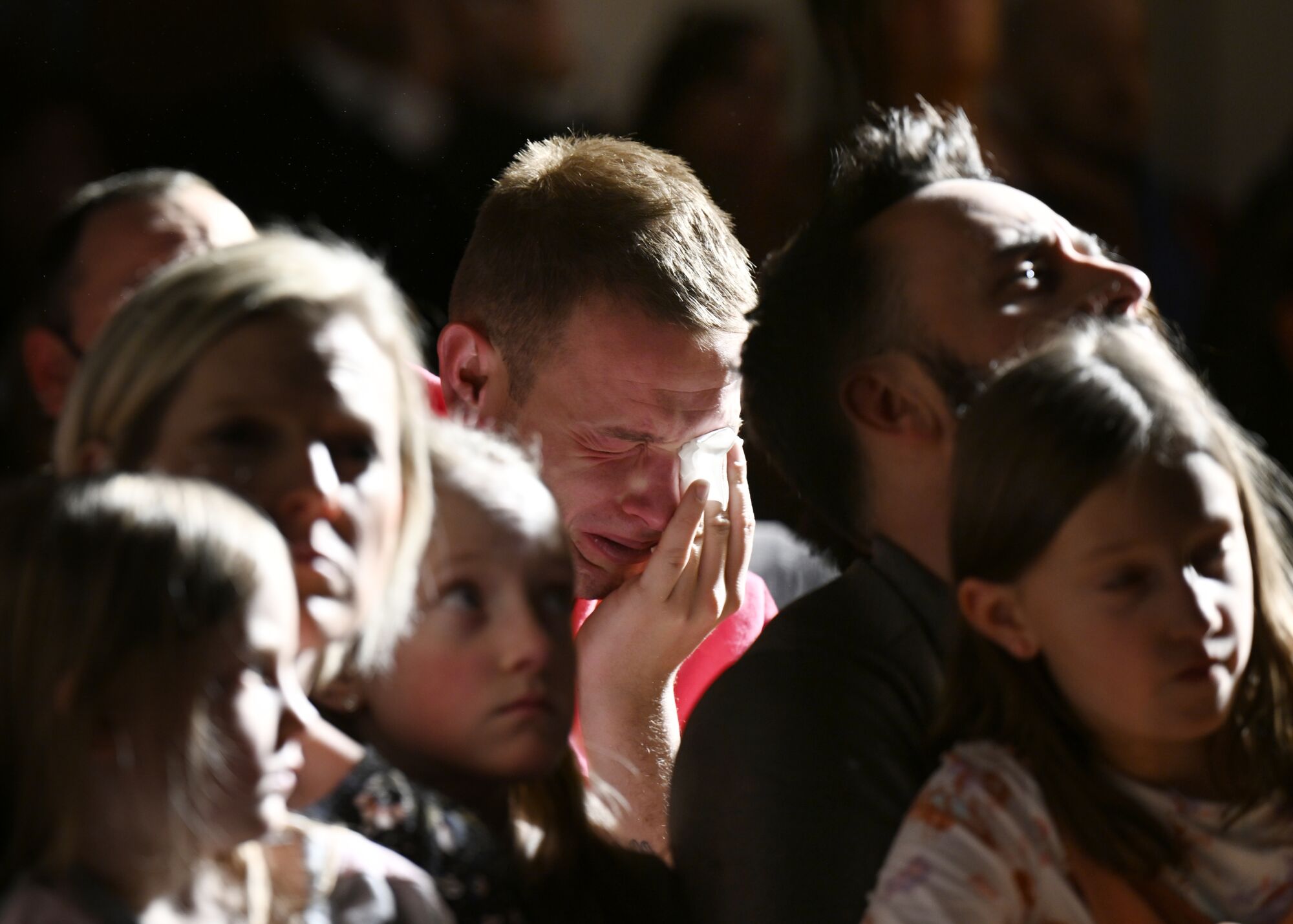 A man weeps at a vigil at All Souls Unitarian Church with others.
