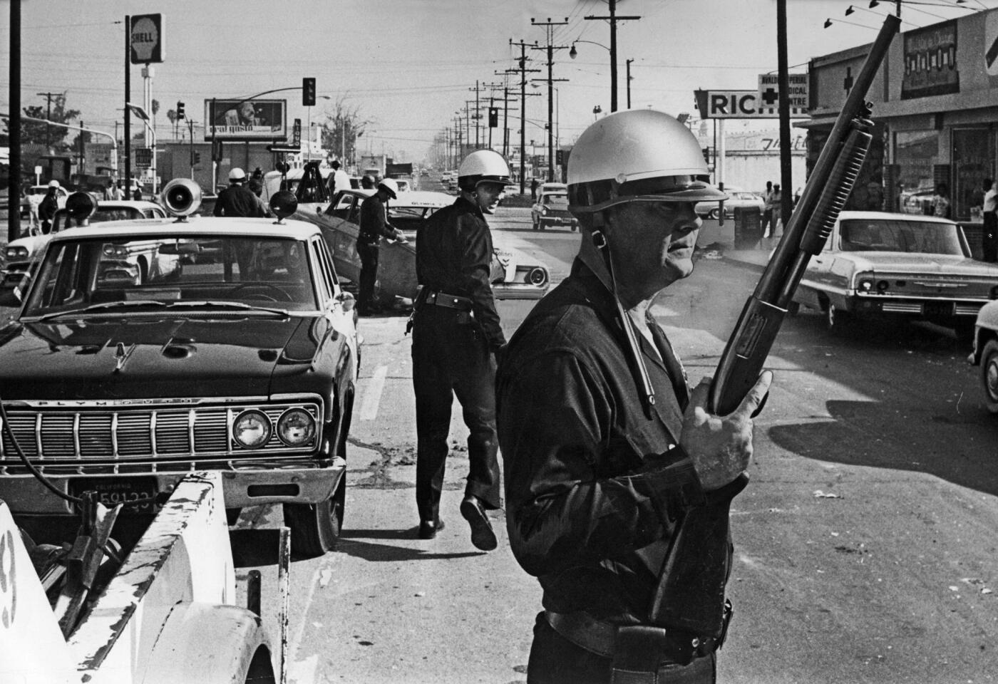 Aug. 13, 1965: Los Angeles police officers stand guard at Avalon Boulevard and Imperial Highway, near Watts.