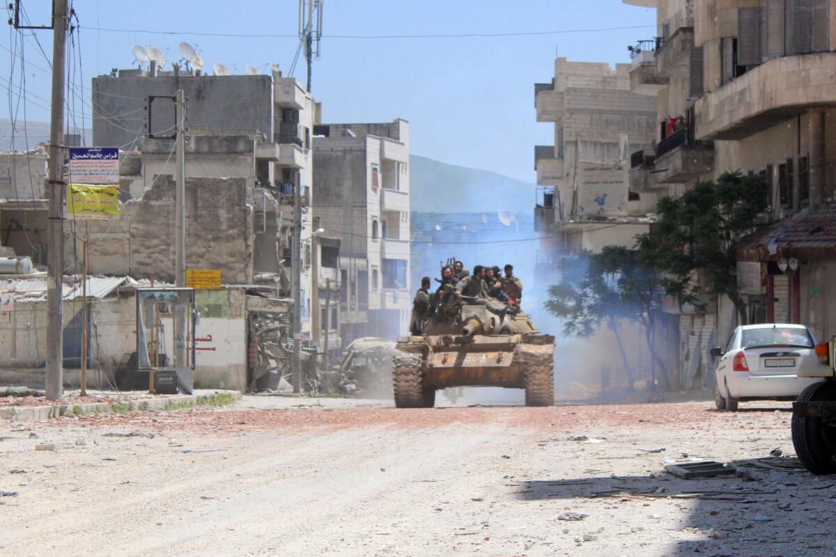 Rebel fighters atop a tank in the northern Syrian town of Jisr al-Shughur on April 26.