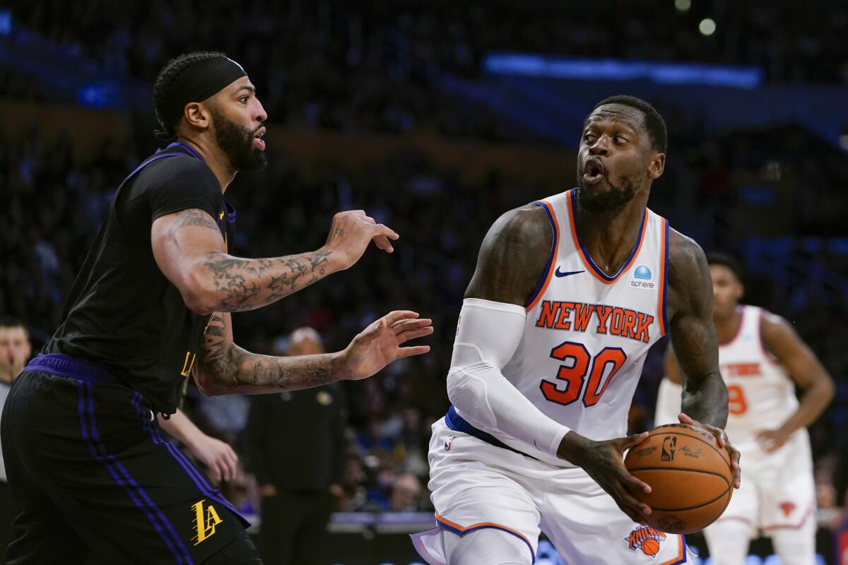 Julius Randle, alero de los Knicks de Nueva York, dribla a Anthony Davis, de los Lakers 