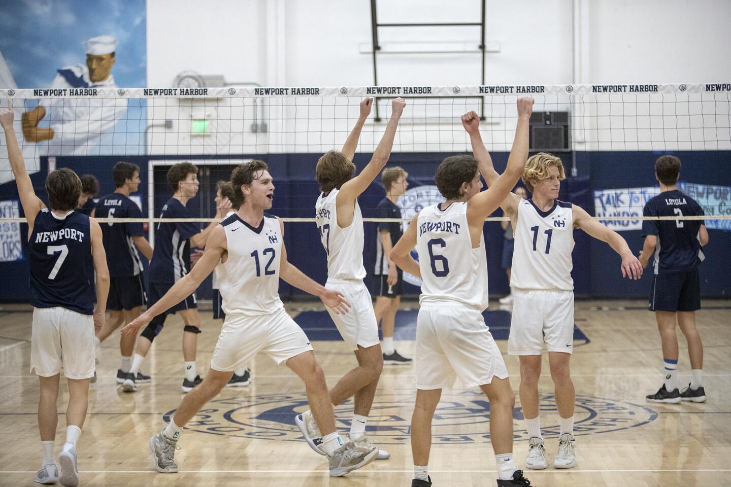 Newport Harbor players celebrate after beating Los Angeles Loyola 27-29, 24-26, 25-19, 25-13, 15-9 during the CIF State Southern California Regional Division I semifinal playoff match in Newport Beach on Thursday.