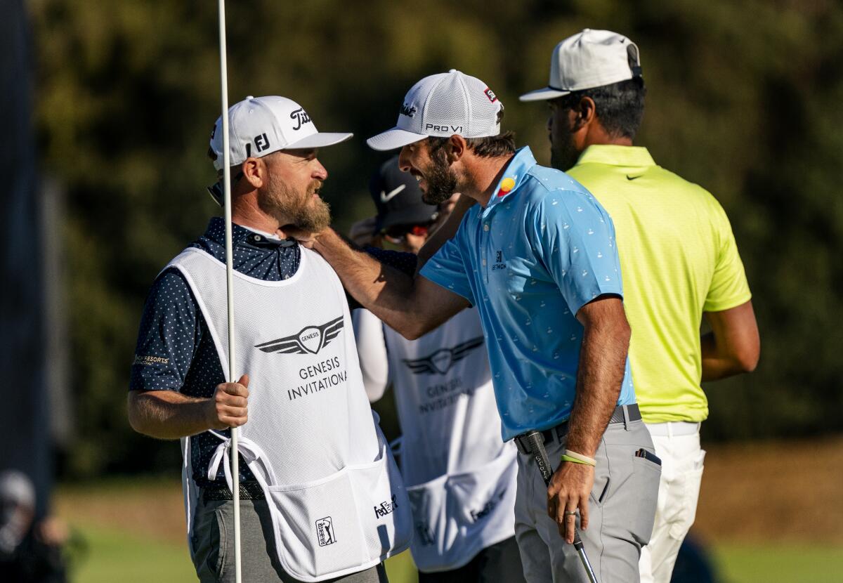 Max Homa celebrates with his caddie after beating Tony Finau on the second playoff hole to win the Genesis Invitational.