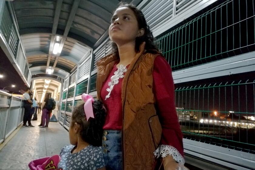 Honduran asylum seeker Alejandra Amador, 24, arrived at the border bridge to Laredo, Texas, before dawn with 4 year-old daughter Natalie to attend her U.S. immigration court hearing at a massive new tent next to the bridge. At 4:30 a.m. Monday, 19 migrants were ushered across the dividing line of an international bridge connecting Nuevo Laredo, Mexico, to Laredo, Texas, and into the new Homeland Security tent court complex. Reporters and legal observers were barred from entering the facility. (Daniel Mendez photo)