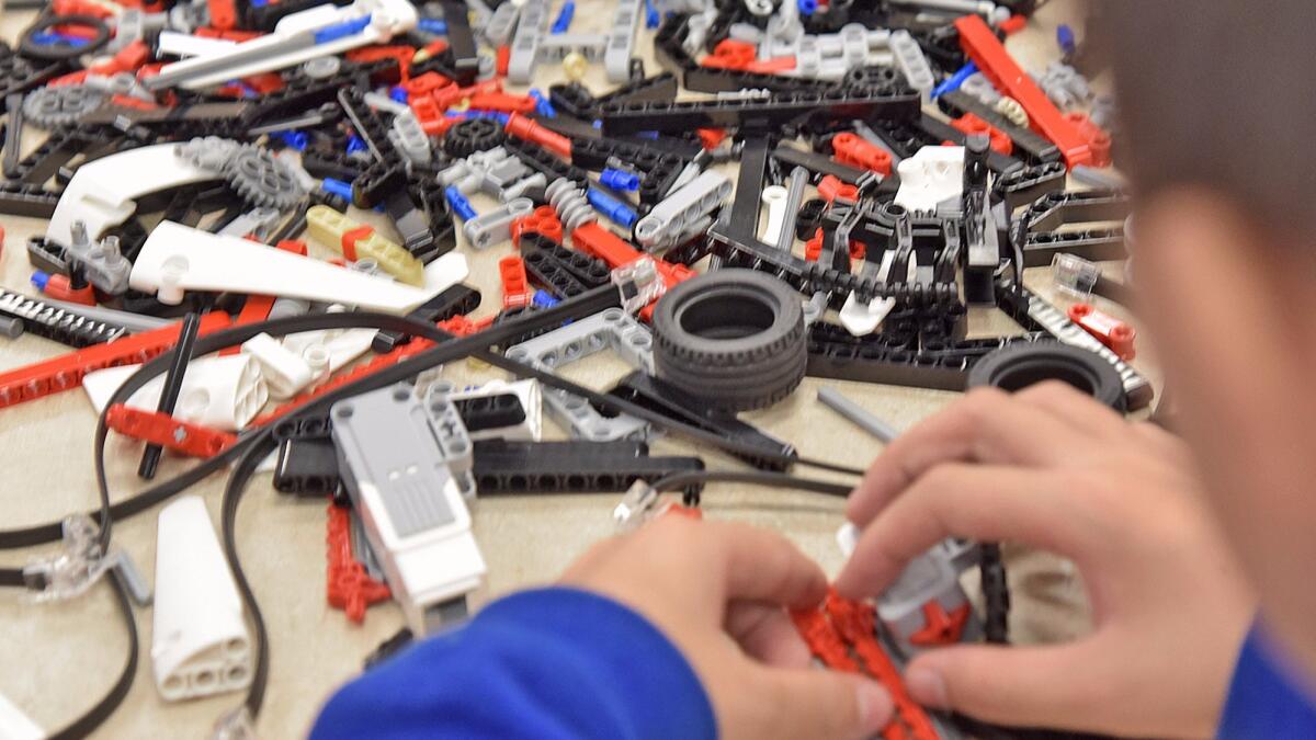 One of the attendees picks from a pile of parts as he assembles his team's robot during the Lego Robo-Camp held at the Buena Vista Branch Library in Burbank on Monday.