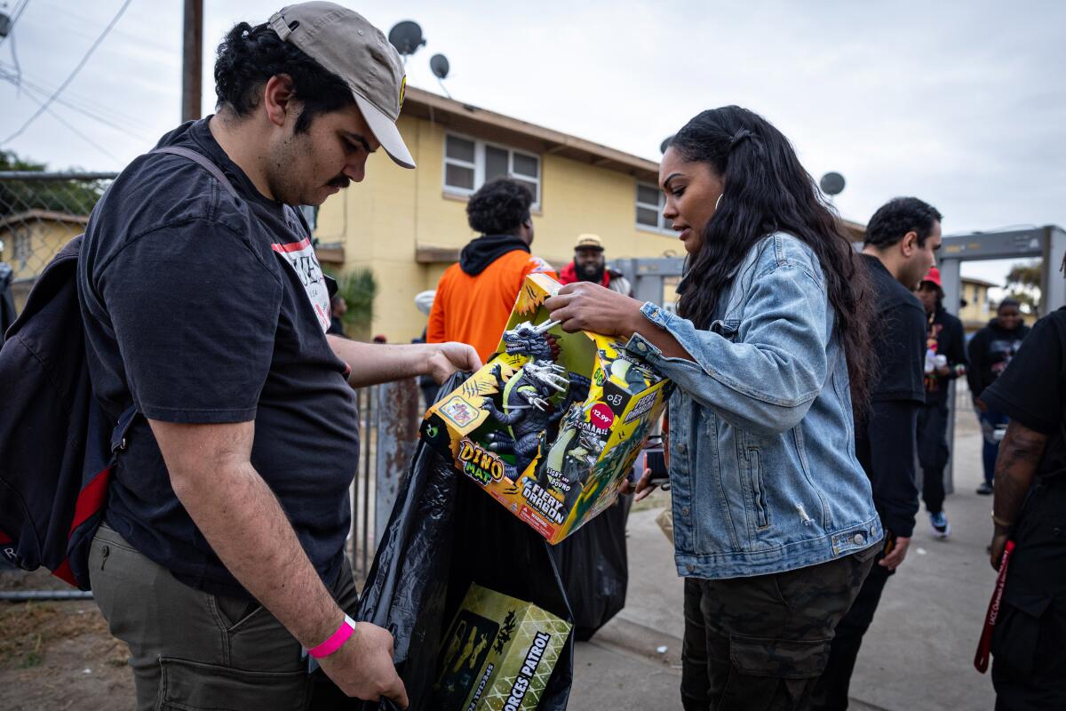 People drop off donations as they enter Top Dawg Entertainment's annual toy drive and concert Tuesday in Los Angeles.
