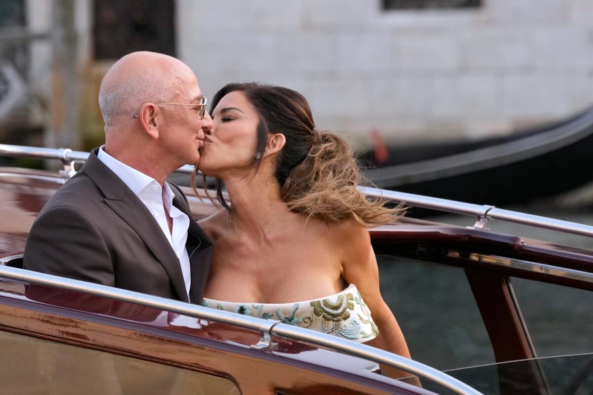 Jeff Bezos and Lauren Sánchez share a kiss on a boat.
