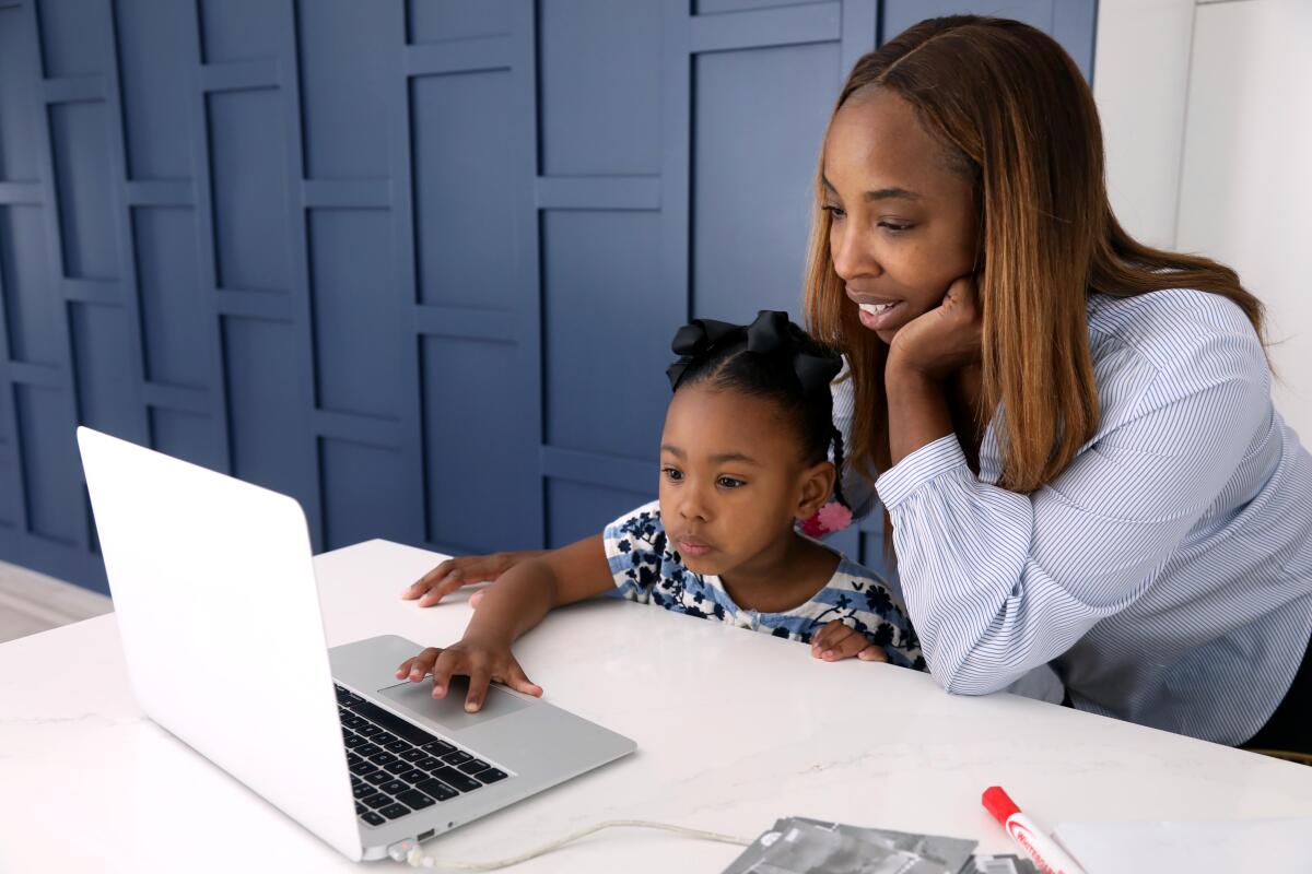 Cali Corbin, 5, a kindergartner at Westwood Charter School, works on a mathematical exercise with her mother Renee Bailey