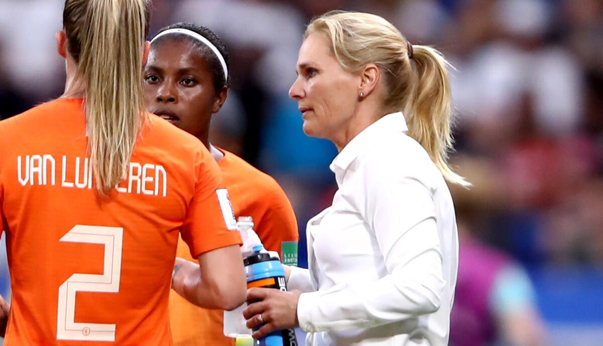 Netherlands coach Sarina Wiegman talks to Desiree Van Lunteren and Lineth Beerensteyn during their semifinal victory over Sweden.