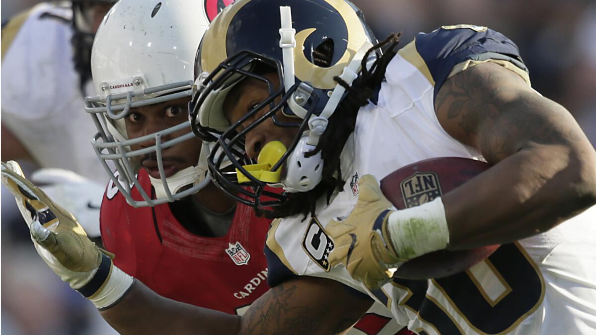 Rams running back Todd Gurley strains for yardage as Cardinals defensive tackle Corey Peters closes in for the tackle during the second half Sunday.