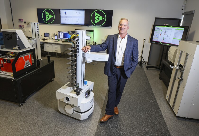 Biosero CEO Tom Gilman with a mobile lab robot at the company's San Diego headquarters. 
