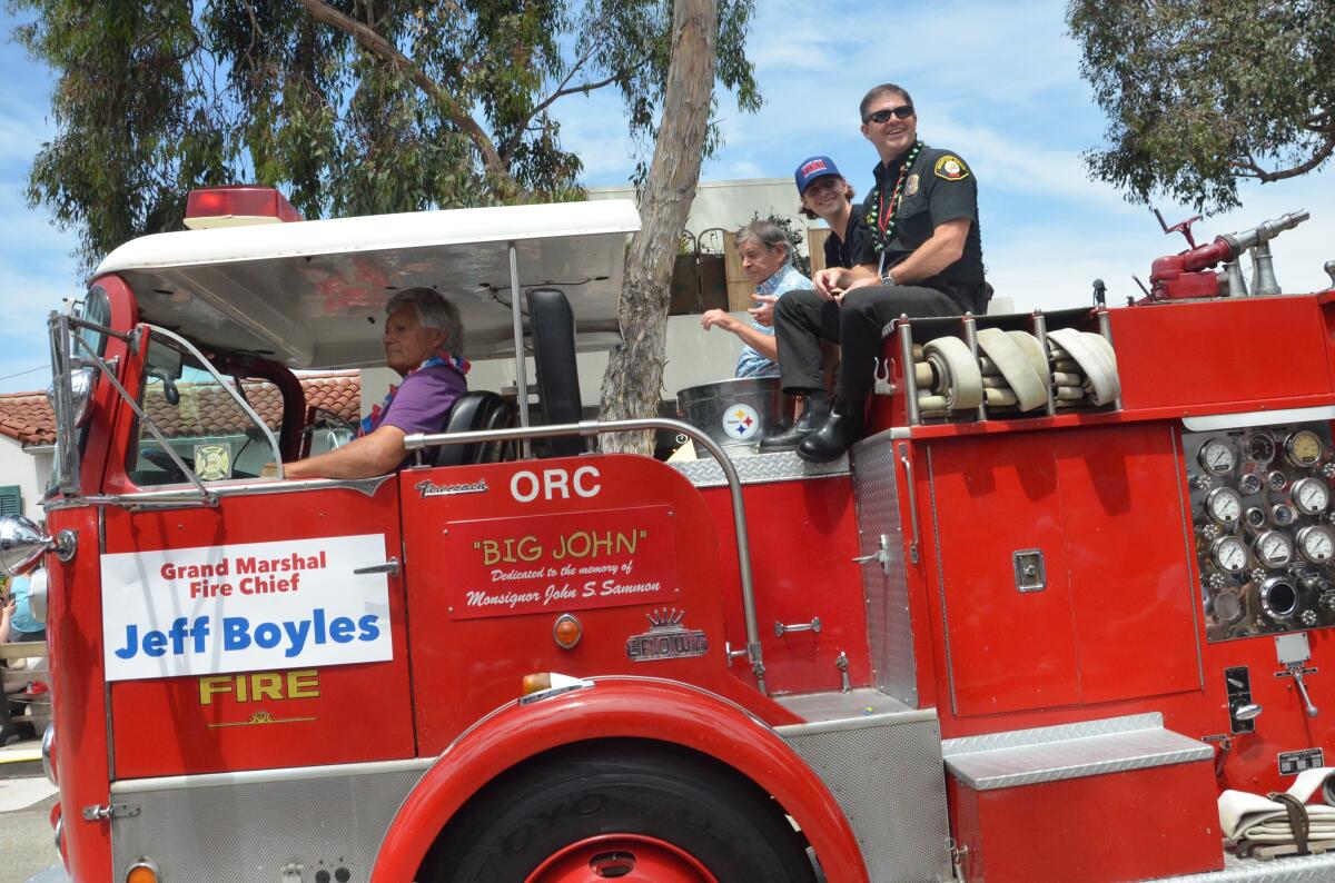 Newport Beach Fire Chief Jeff Boyles, grand marshal of the 30th annual Balboa Island Parade rides atop a 1966 fire engine.