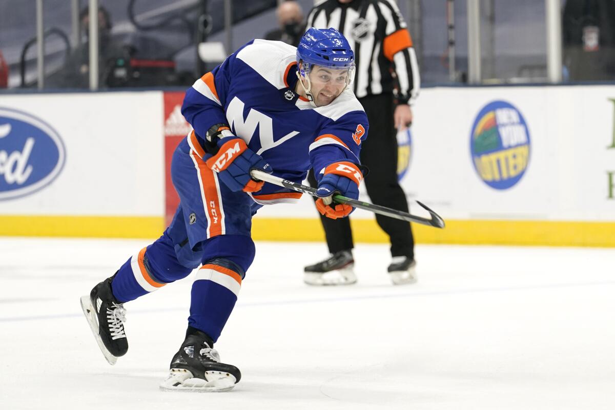New York Islanders defenseman Adam Pelech (3) watches his shot during the second period of the team's NHL hockey game against the New Jersey Devils, Thursday, March 11, 2021, in Uniondale, N.Y. (AP Photo/Kathy Willens)