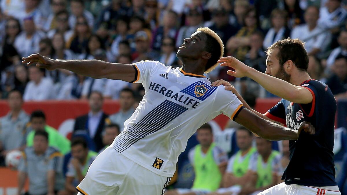 Galaxy forward Gyasi Zardes, left, fights for control of the ball against New England Revolution defender A.J. Soares during the first half of the Galaxy's MLS Cup win on Dec. 7. Zardes has made a positive impact while training on the U.S. national team.
