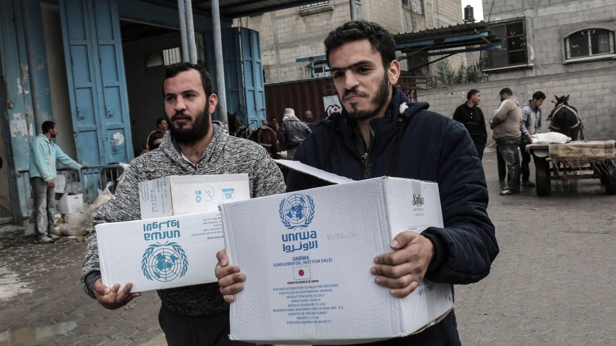 Palestinian refugees collect aid parcels at a United Nations food distribution center in Khan Yunis in the southern Gaza Strip on Jan. 28, 2018.