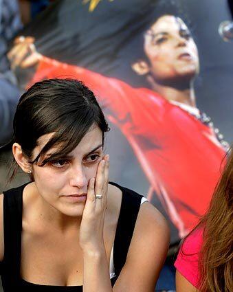 A woman cries in Madrid during a tribute to the pop star.