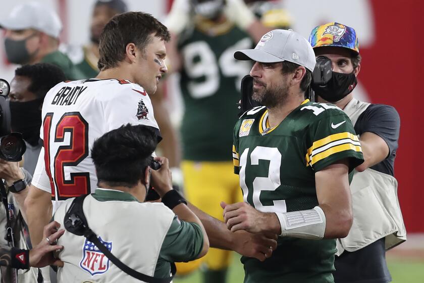 Tampa Bay Buccaneers quarterback Tom Brady, left, shakes hands with Green Bay Packers quarterback Aaron Rodgers.