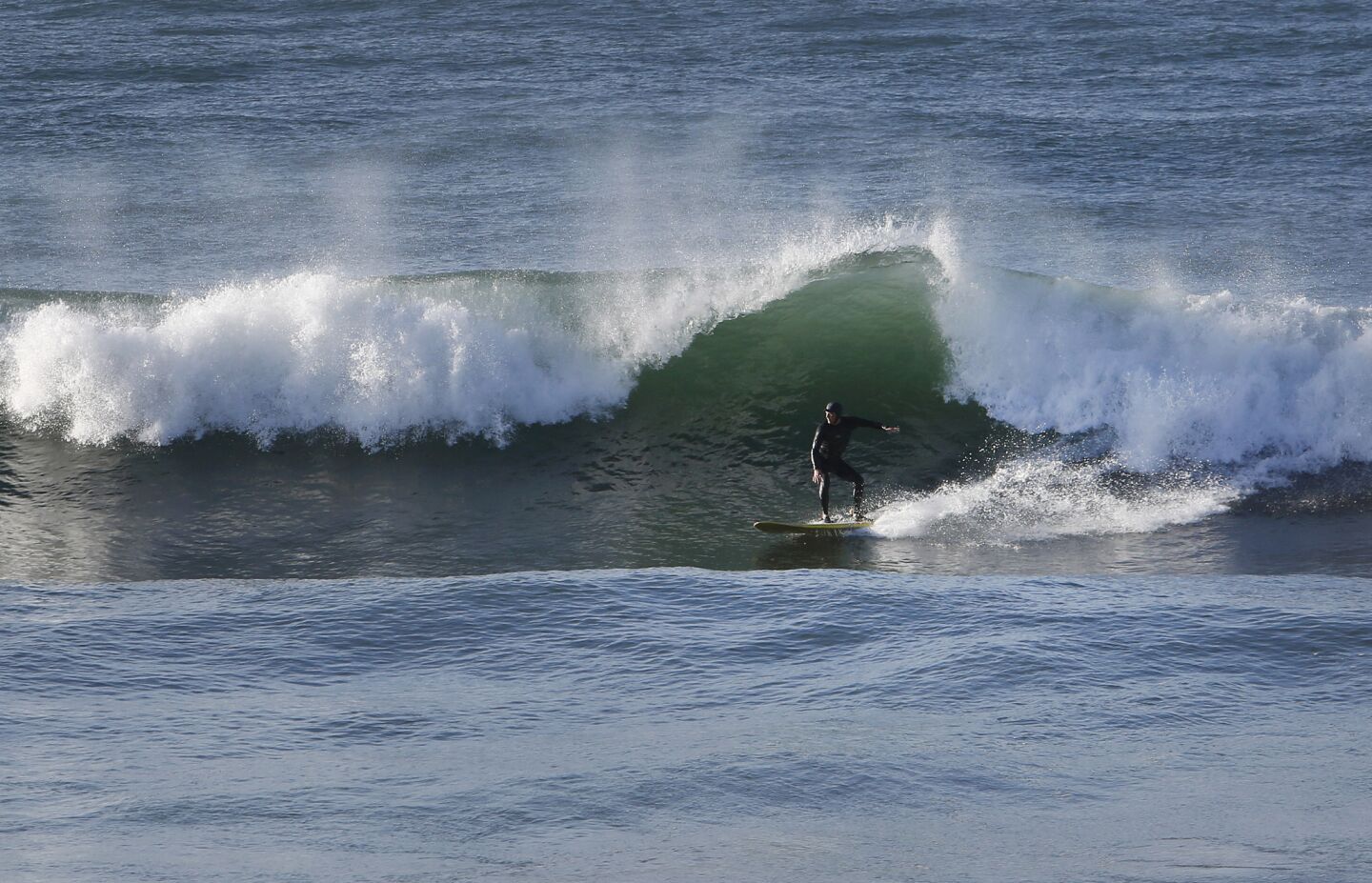 A surfer catches a wave at Sunset Beach in the Pacific Palisades.