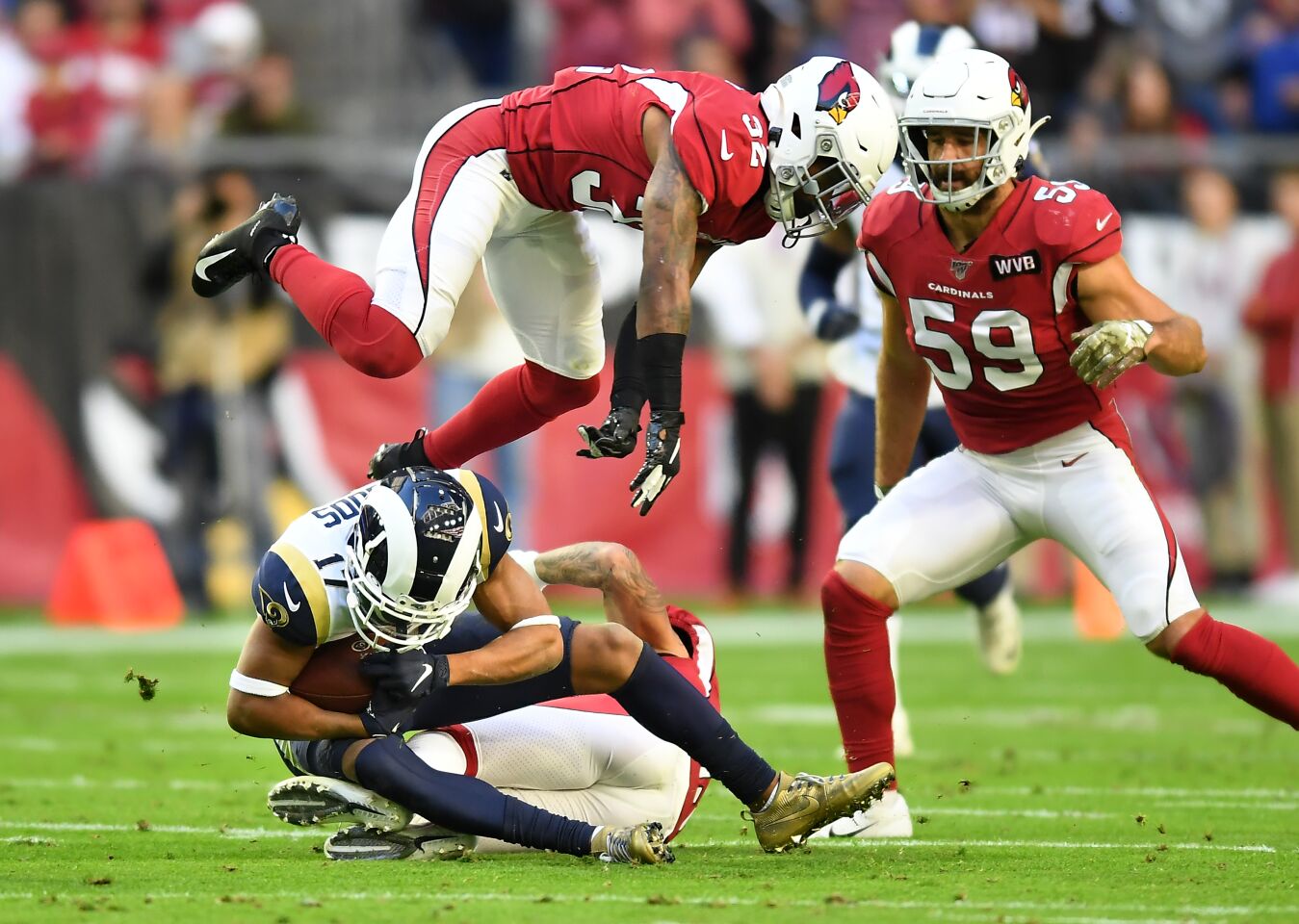 Rams wide receiver Robert Woods makes a reception as Cardinals safety Budda Baker leaps over him in front of linebacker Joe Walker.