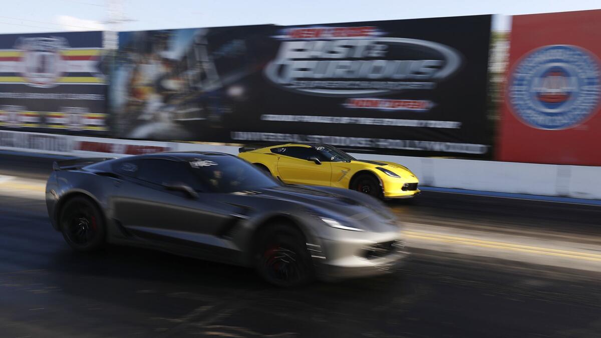 A pair of late-model Corvettes race at Irwindale Speedway.