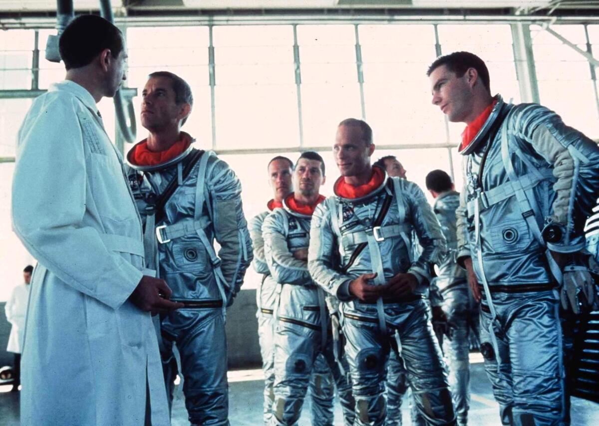 Scott Glenn as Alan Shepherd confronts a NASA scientist about changes to the Mercury capsule while the other astronauts (Charles Frank as Scott Carpenter, Fred Ward as Gus Grissom, Ed Harris as John Glenn and Dennis Quaid as Gordon Cooper) provide moral support.