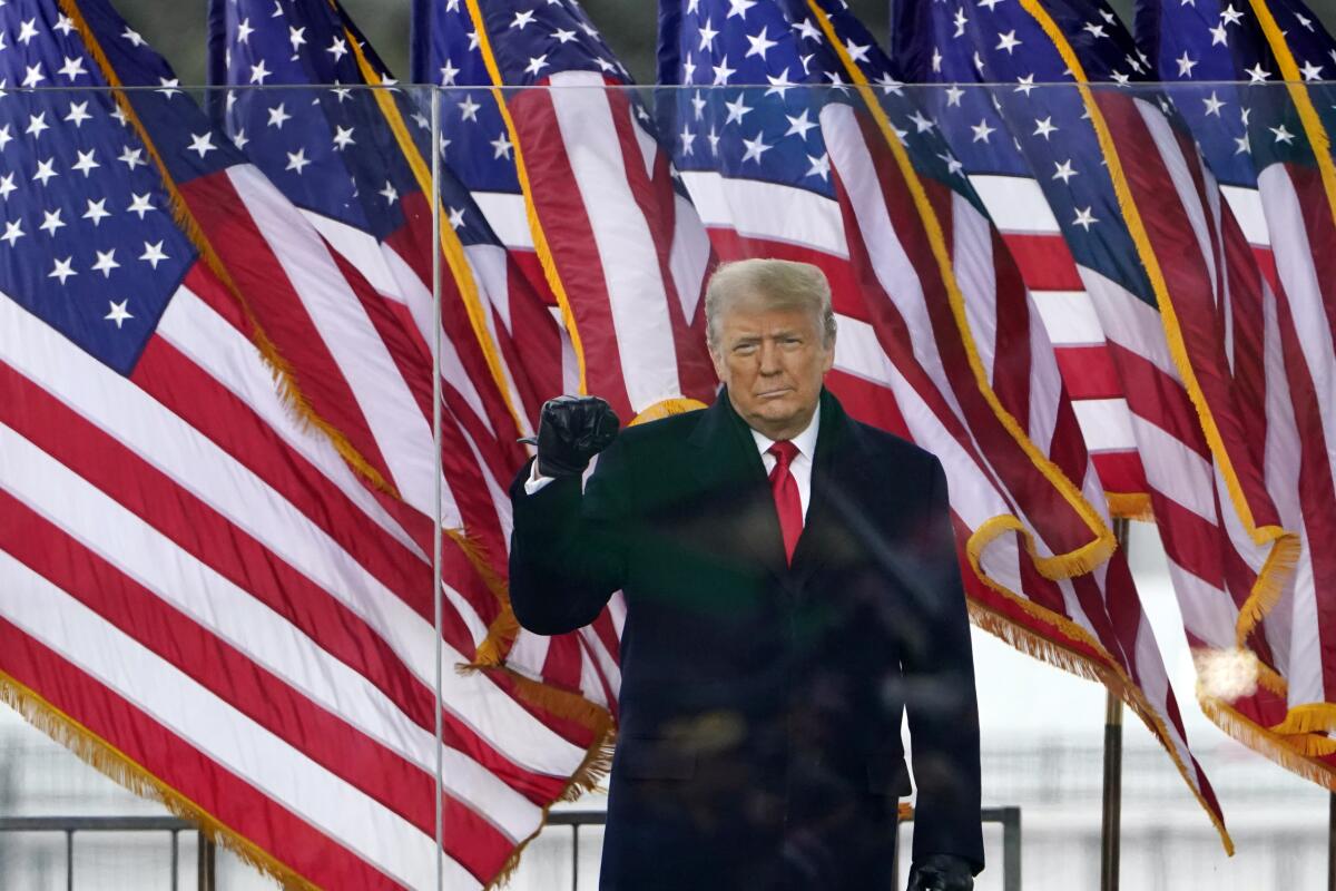 President Trump at a rally Jan. 6 with U.S. flags beside him.