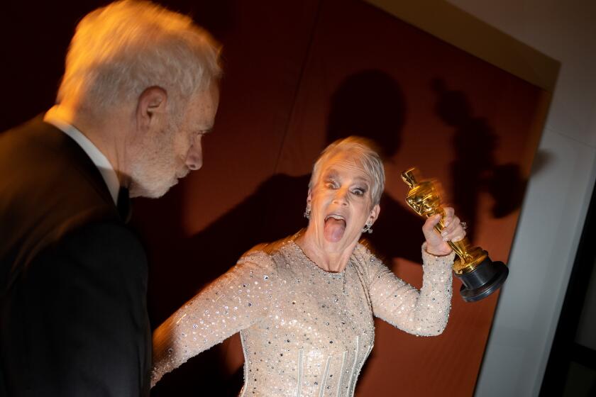 HOLLYWOOD, CA - MARCH 12: Actress Jamie Lee Curtis holding her Best Actress in a Supporting Role Oscar, with husband Christopher Guest, arriving at the Governors Ball, following the 95th Academy Awards at the Dolby Theatre on March 12, 2023 in Hollywood, California. (Jay L. Clendenin / Los Angeles Times)