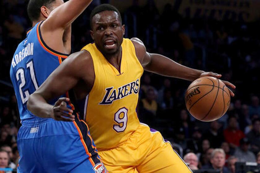 Lakers forward Luol Deng works to the basket against Oklahoma City Thunder forward Andre Roberson in the first quarter Tuesday at Staples Center.