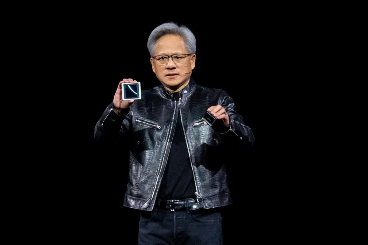 Nvidia chief Jensen Huang displays a chip during a tech conference in San José.