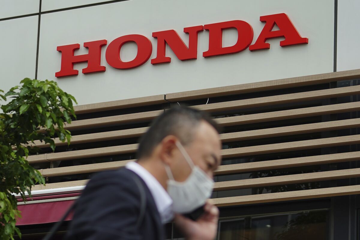 A man wearing a protective mask to help curb the spread of the coronavirus walks past the logo of Honda Motor Company in Tokyo on May 13, 2021. Honda returned to profitability in April-June, recording a 222.5 billion yen ($2 billion) profit, as better sales and costs cuts added to the Japanese automaker’s bottom line. (AP Photo/Eugene Hoshiko)