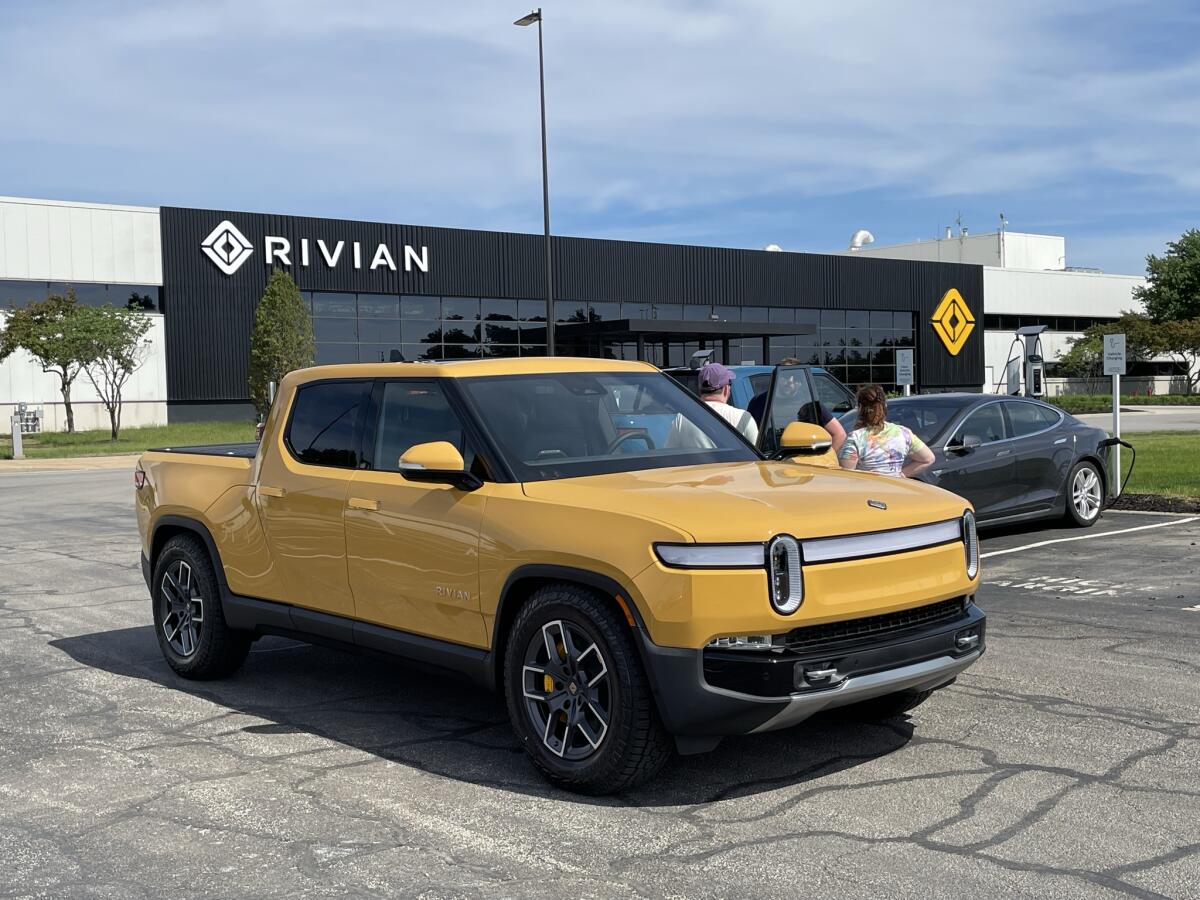 A yellow truck next to a family in a parking lot