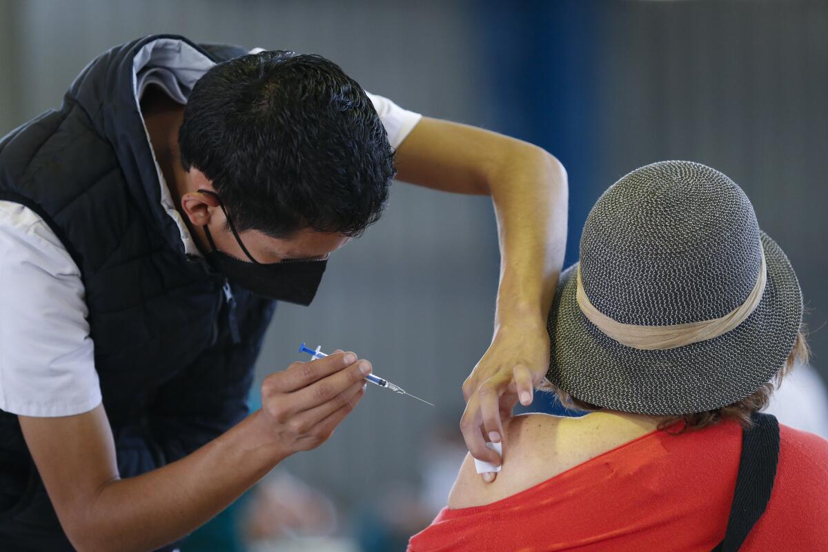 Un trabajador médico le inyecta a una mujer una dosis de la vacuna rusa Sputnik V