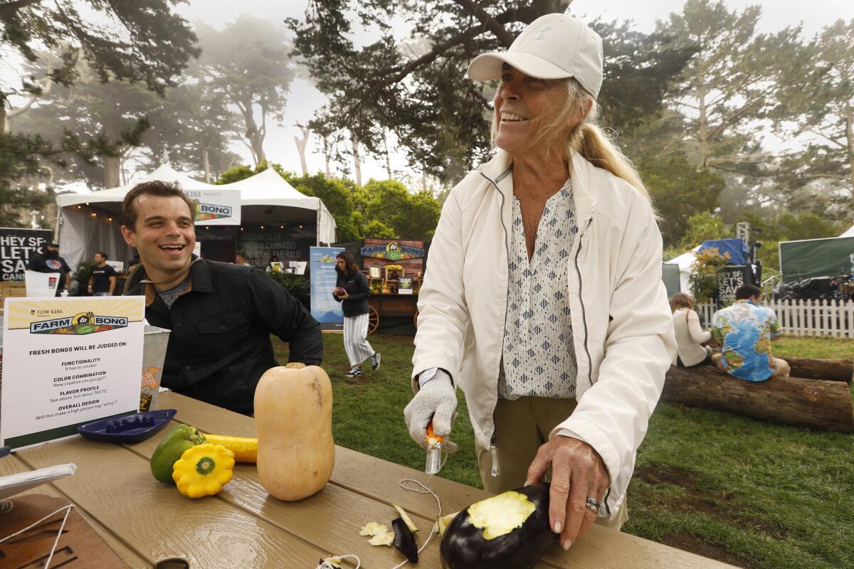 Janna Lutz, 65, of Ohio, and her son Brian Lutz, 24, of San Jose, make a bong out of vegetables for a farm to bong contest at Grass Lands at the 2019 Outside Lands festival in San Francisco. (Carolyn Cole/Los Angeles Times)