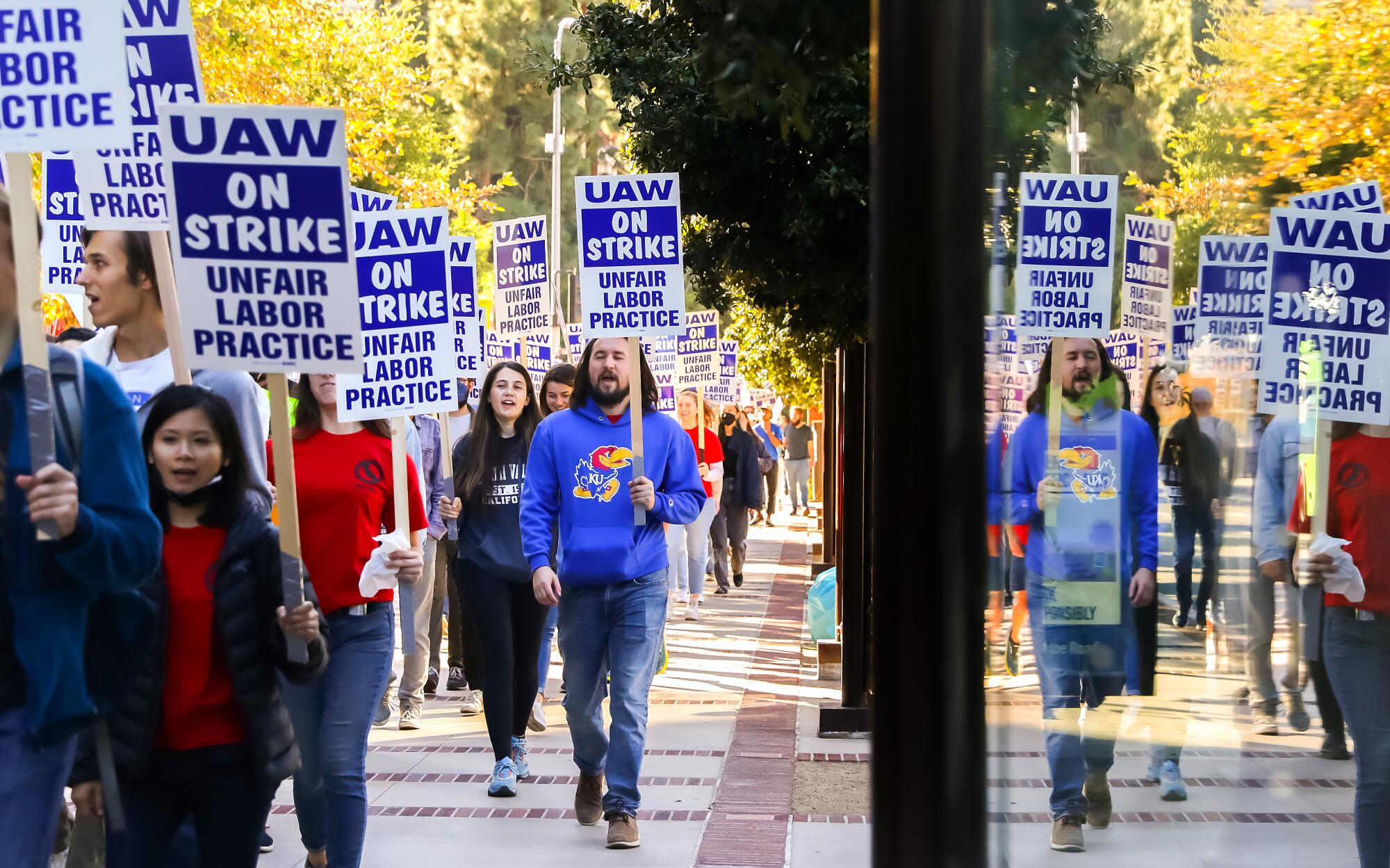 Demonstrators are seen reflected in a window as they picket   at UCLA.