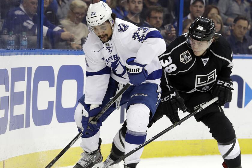 Tampa Bay Lightning right wing J.T. Brown, left, moves the puck ahead of Kings defenseman Paul LaDue during the second period.