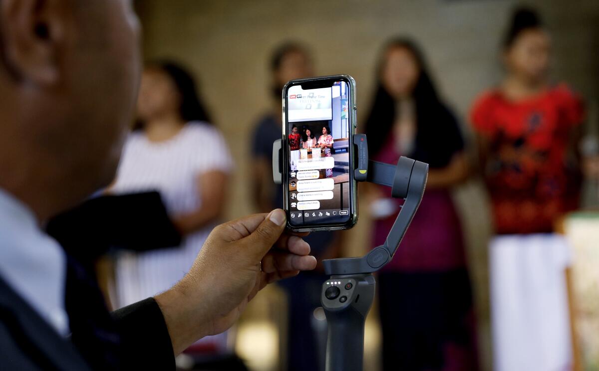 Pastor Kitione Tuitupou, left, livestreams services from inside First United Methodist Church of Bellflower.