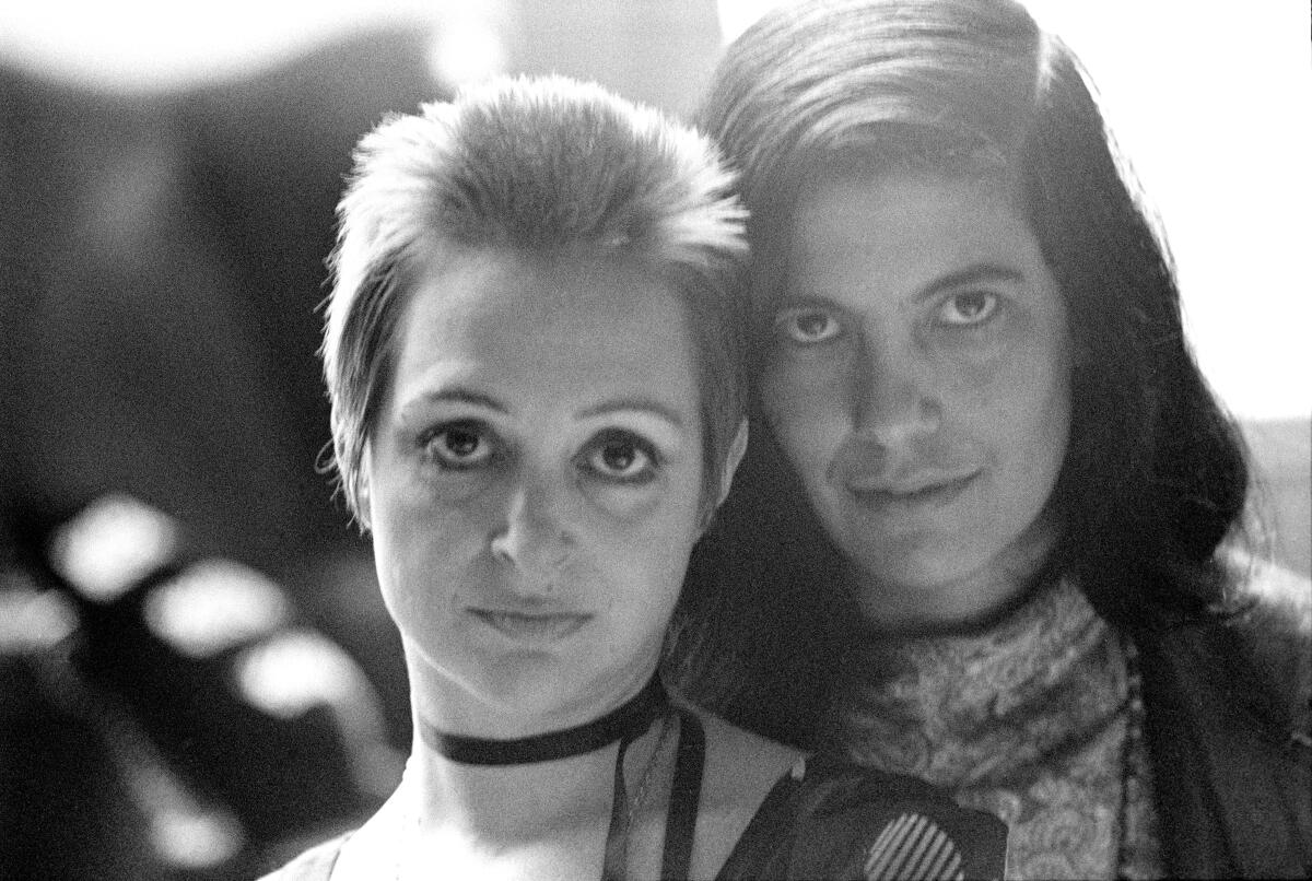 Two women pose for the camera in a black-and-white still.