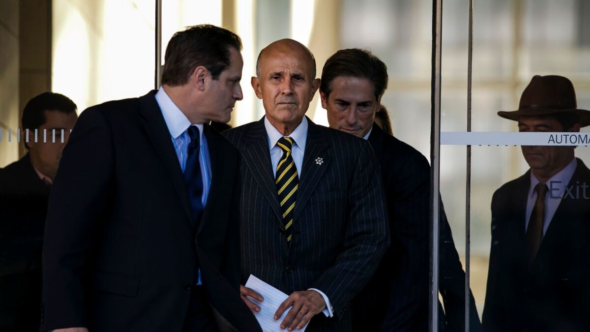 Former Los Angeles County Sheriff Lee Baca leaves federal court Dec. 22 after his mistrial on obstruction charges. His retrial is scheduled to begin next week.