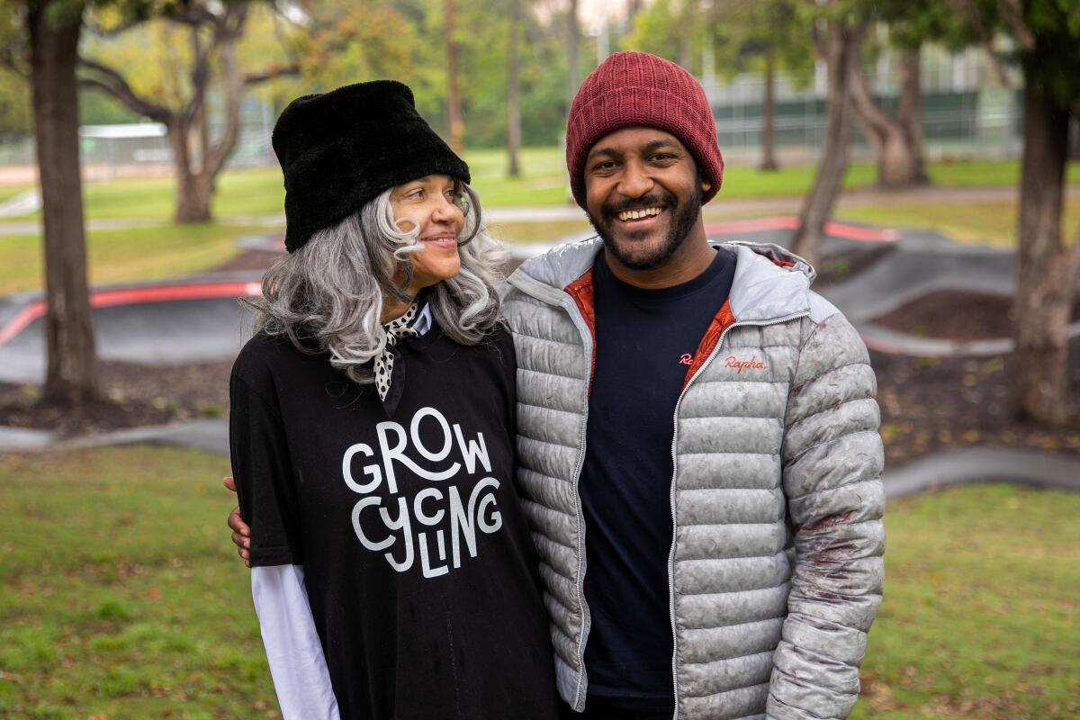 A woman and a man standing together in a park.