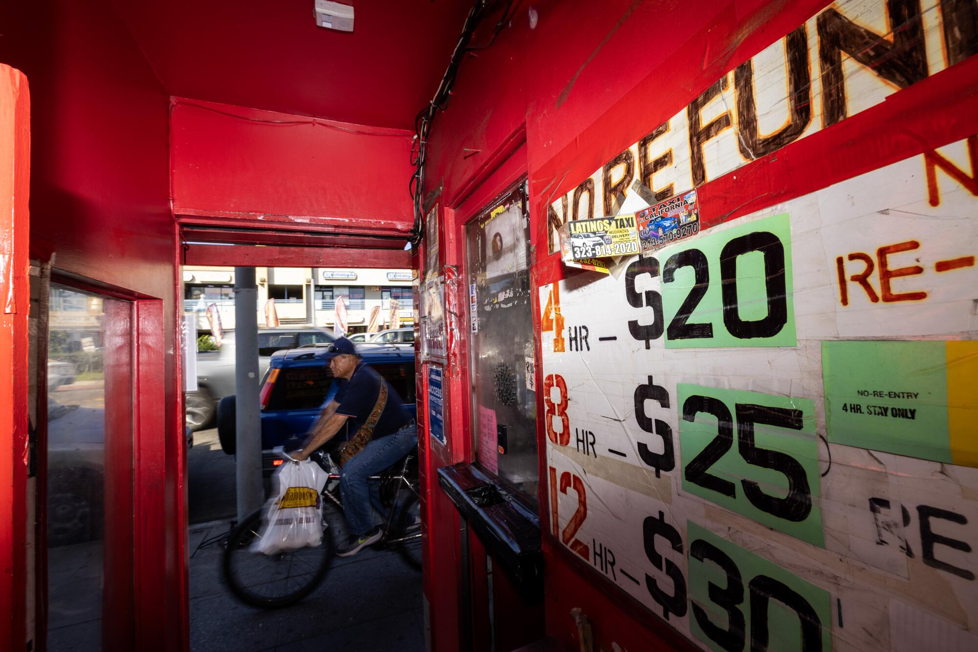 A cyclist rides past the entrance to the Tiki Theater on Santa Monica Boulevard.