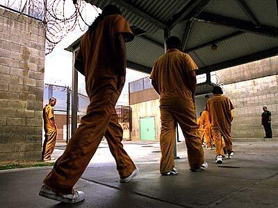 Walking single file, inmates at Theo Lacy Men's Jail enter the mess hall to eat lunch.