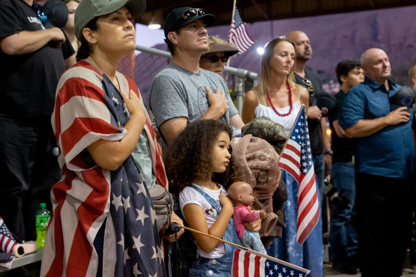 Los Angeles, CA - September 4, 2021: Malina Shaw, a veteran, says the pledge of allegiance with her family during a vigil to say good-by to Marine Cpl. Kareem Nikoui, who was killed in the Kabul airport suicide bombing, during a vigil at George Ingalls Equestrian Event Center in Norco, California on Saturday, September 4, 2021. CREDIT: Allison Zaucha for The New York Times.
