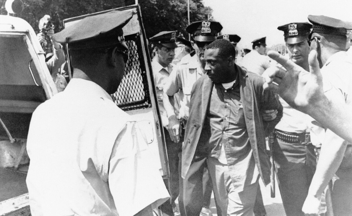 Comedian Dick Gregory is escorted to a police van in Grant Park as police broke up a march of civil rights demonstrators in Chicagoin 1965. They were en route to City Hall after a court had enjoined them from carrying out a school boycott.